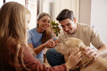 Happy family playing with dog after moving into new home