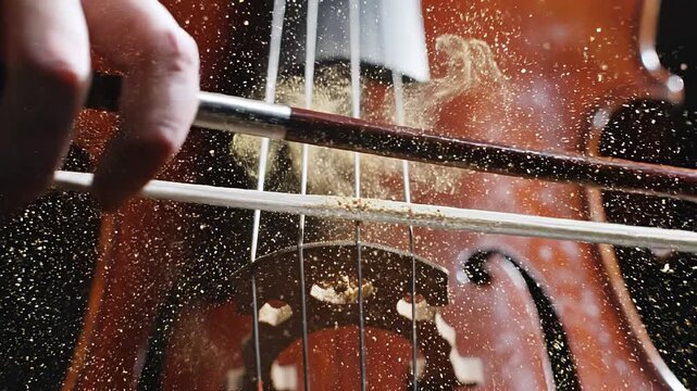 Cello bow vibrating strings creating rosin dust explosion