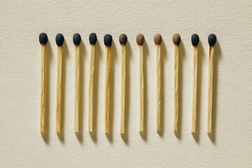 Lined up wooden matches, heads showing signs of burning