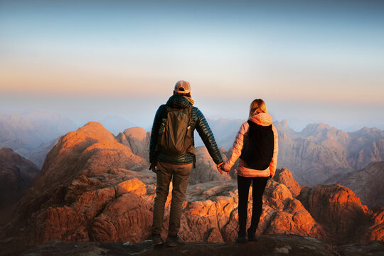 Couple in love enjoying views on Sinai mount top people holding hands hiking in Egypt, friends man and woman travel together on romantic vacations Valentines day adventure tour family holidays