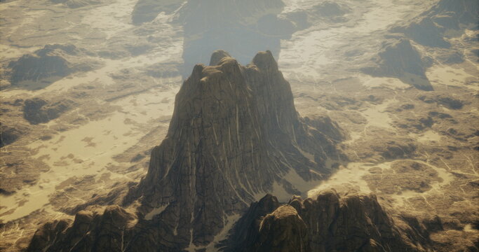 Majestic mountain peaks jut out prominently from a sprawling desert terrain. The sunlight casts shadows over the rugged surface, highlighting the stark contrast of light and dark.