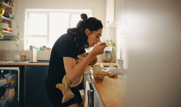 Mother feeds baby at the kitchen counter