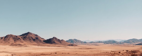 Wide empty desert valley with distant rocky mountains under a clear blue sky creating vast open space and natural minimal scenery for environmental and climate concepts