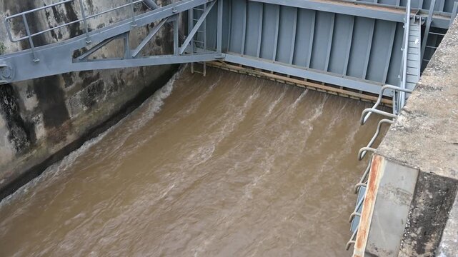 Spillway of Chiang Rai dam open for release water. Spillway, passage for surplus water over or around a dam when the reservoir itself is full.