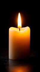 White candle with flame glowing in dark background  