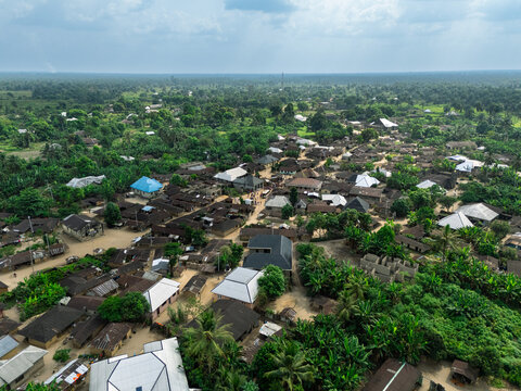 Aerial view of a village nestled amidst a sea of verdant trees, structures with roofs of varying colors, Ubarama, Rivers, Nigeria.