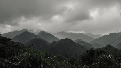 Misty, layered mountain range under a cloudy, overcast sky