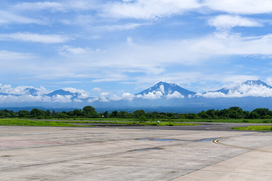 Runway view at Banyuwangi International Airport with a striking panorama of Mount Baluran, Mount Ijen, Mount Raung, and Mount Arjuna lining the horizon.