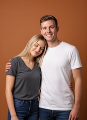 Fototapeta premium smiling young couple hugging, blonde woman resting on man’s shoulder, casual studio portrait on warm brown background, love concept