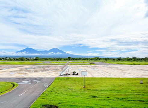 Runway view at Banyuwangi International Airport with a striking panorama of Mount Baluran, Mount Ijen, Mount Raung, and Mount Arjuna lining the horizon.