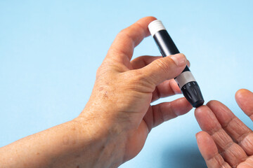 Elderly woman checking her blood sugar level.