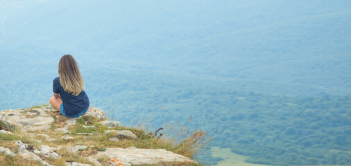 Young girl enjoying time in the edge of a cliff.