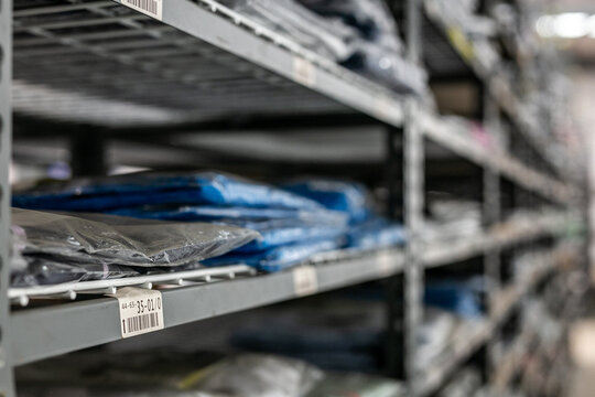 Industrial warehouse interior with metal shelves used for organised storage and picking of garments or stock
