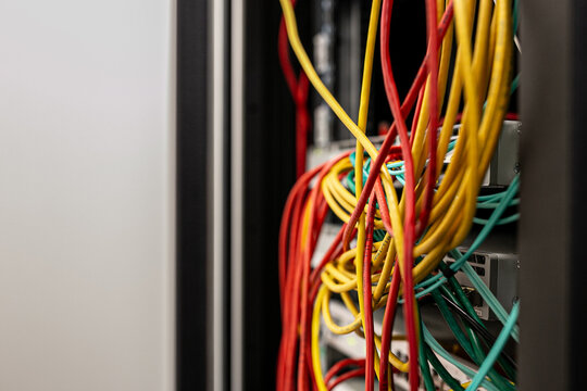 Yellow and red Ethernet cables connected to a network switch or patch panel, representing data networking and IT infrastructure