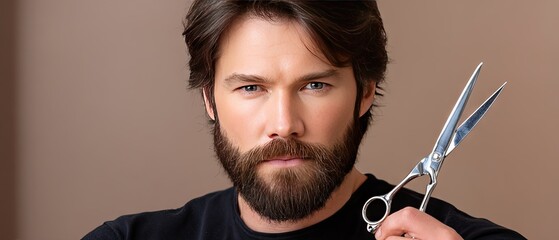 Handsome man with scissors and comb in hairdressing scene on brown background with copy space for hair salon promotion