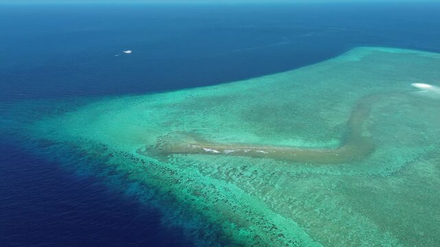 Drone captures reef edge and surrounding color gradient between shallow reef and deeper ocean near Nil Desperandum.