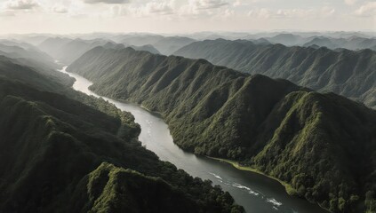 River valley winds through lush, green mountain ranges under cloudy skies