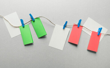 Colored cards hanging with blue clothespins, gray background
