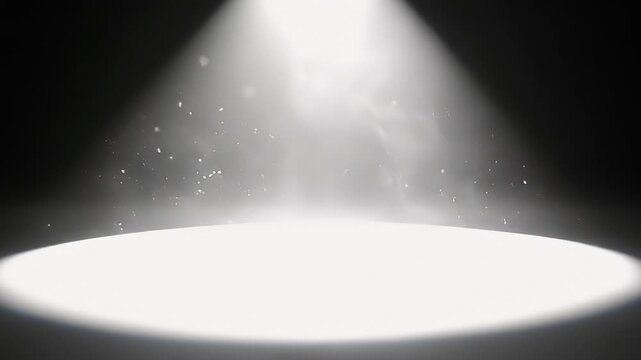 A dramatic and powerful spotlight illuminates a circular area on a deep, dark background, creating an intense focal point. Fine dust particles or shimmering elements are visible within the bright beam