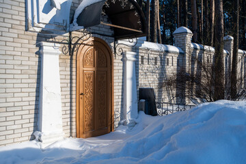entrance to a brick building with a carved wooden door.