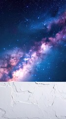 A striking vertical composition contrasting the vibrant Milky Way galaxy above a textured white stucco background below.