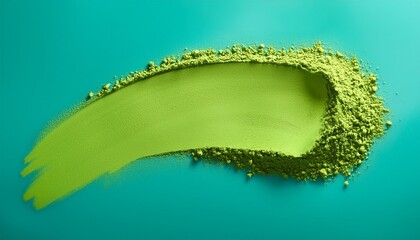 green matcha powder in shape of brush stroke on plain teal background green tea