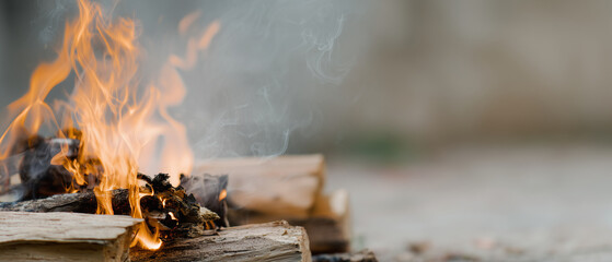 Hyperrealistic premium commercial stock photo banner of a ceremonial outdoor fire burning on stacked wood, wide composition with the flames placed on the left third, large clean co