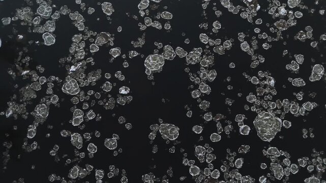 Aerial view of ice fragments dance on the dark, reflective water, creating a mesmerizing pattern of light and shadow, Vilnius, Lithuania.