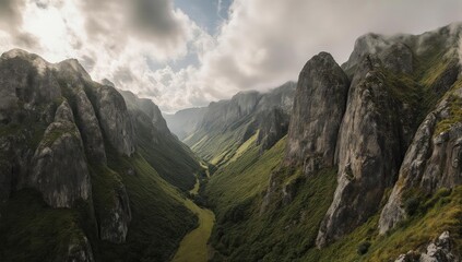 Deep valley with high rock formations and wispy clouds overhead