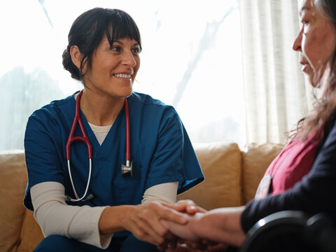 Native American nurse comforts elder female patient during home health visit
