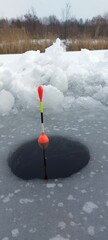 Ice fishing float in frozen lake during winter. © stepacarp23