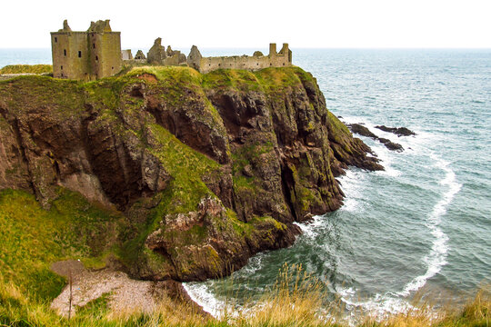 The Ruins of Dunnator Castle on the headland jutting out into the North Sea, along Scotlands rugged coast