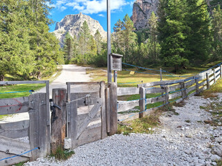 A gate with a hanging round stone on a rope in the Alto Adige Mountains. A locking mechanism on a mountain gate to protect pets.