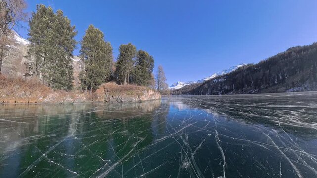 Mirror reflections on crystal-clear frozen Lake Sils in the Engadin, Switzerland