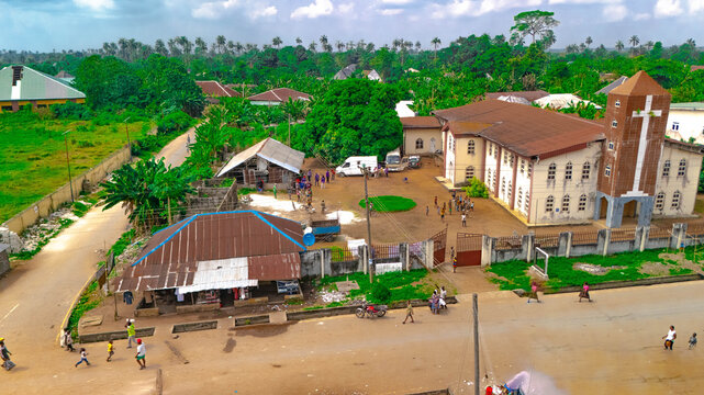 Aerial view of the contrast between the old corrugated iron roofed houses and the grand church, a juxtaposition of tradition and faith, Oduoha-Emuoha, Rivers, Nigeria.