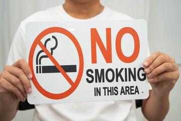 Male holding a no smoking sign.