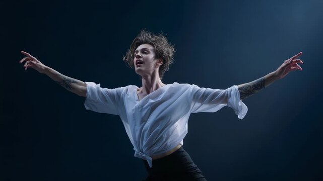 Leaping male dancer reacting to spotlight on theater stage, showing tied shirt and forearm tattoos