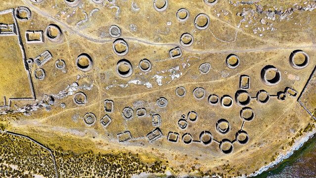 Aerial view of mysterious stone circles and rectangular structures dotting the arid landscape, like ancient eyes gazing skyward, Mawk'allaqta, Espinar, Cusco, Peru.