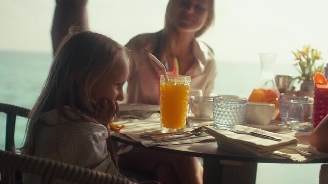 Happy family enjoying a delicious breakfast together at an island resort on vacation