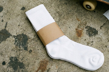 White cotton socks with blank paper label on concrete floor