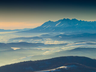 Lot nad Jaworzyną Krynicką popołudniu zimą. Zoom na Tatry.