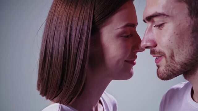 Beautiful young man and woman getting closer, showing affection and tender feelings. Romantic couple in love sharing an intimate moment