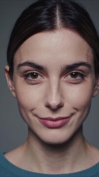 Close up shot of a young woman's face with her features comically warped. As her expression changes, she breaks into a soft smile