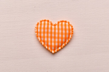 Orange fabric heart shape on light background