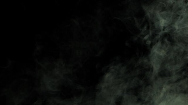 Grey wisps of smoke swirling on dark background super slow motion close up shot selective focus