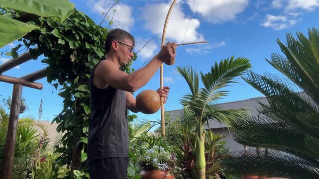 homem tocando birimbau som da capoeira 