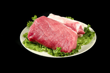 Fototapeta premium Raw Pork Tenderloin and Fresh Lettuce on Black Background