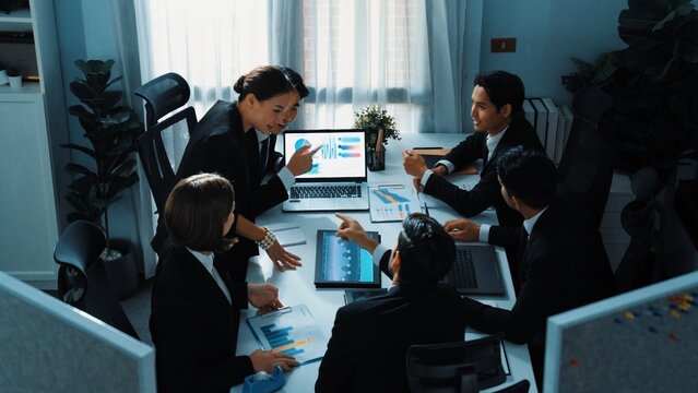 Top view of skilled analytic analysis stock market investment data at meeting. Businessman show increasing graph or financial statistic to investors at table with document and device. Directorate. - Powered by Adobe