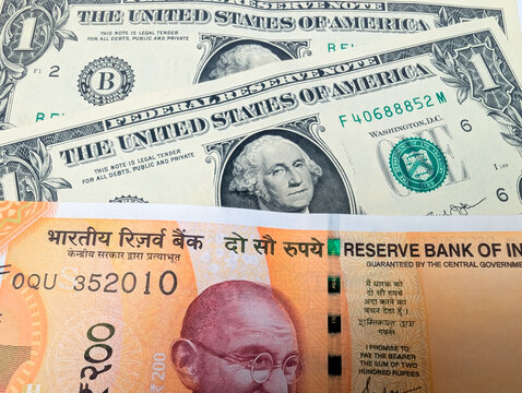 close up of us dollar bills and indian 200 rupee note finance exchange rates economy and international money