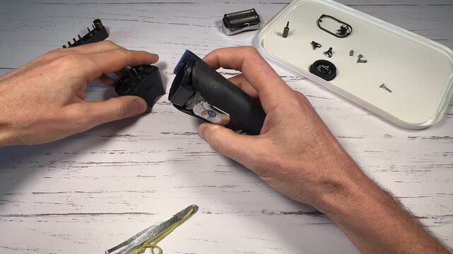 Disassembling a men's electric wireless razor and replacing old batteries - step 5 of 10, part of a series: removing the side plastic from the handle of the razor